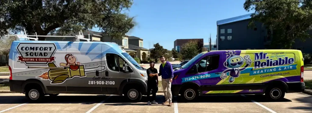 Two people stand between two parked vans with heating and cooling company logos: "Comfort Squad" on the left and "Mr. Reliable Heating & Air" on the right, in a parking lot.